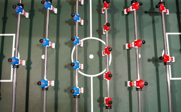 Overhead shot of a coach giving instructions to players during a training session, emphasizing the tactical adjustments allowed by the new substitution rules.