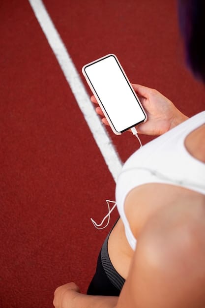 A close-up of a sports fan holding a smartphone displaying a personalized sports news feed with highlights and information tailored to their favorite team and athletes. The background shows a blurred stadium atmosphere.