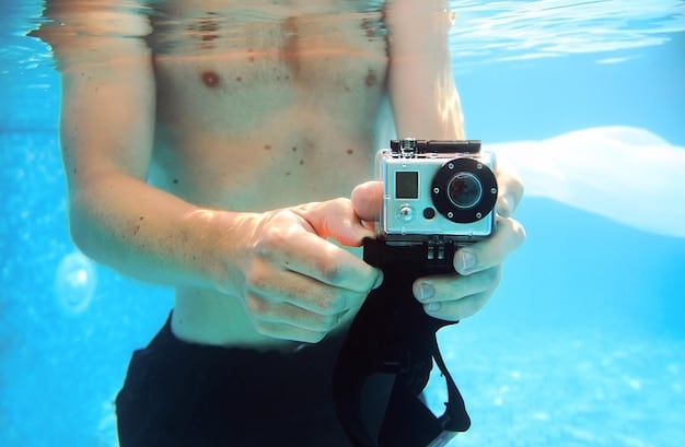 An underwater shot of a swimmer being filmed by a waterproof camera, with a coach reviewing the footage on a tablet poolside.