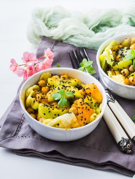 Close-up of a vibrant quinoa salad with juicy mango chunks, black-eyed peas, crunchy cashews, and fresh cilantro, drizzled with a light lime vinaigrette, served in a colorful ceramic bowl.