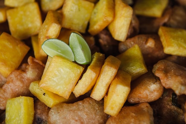 A close-up shot of a variety of dishes made with cassava, including cassava fries, cassava cake, and cassava bread, arranged artfully on a wooden platter. The focus is on the texture and color of the cassava-based foods.